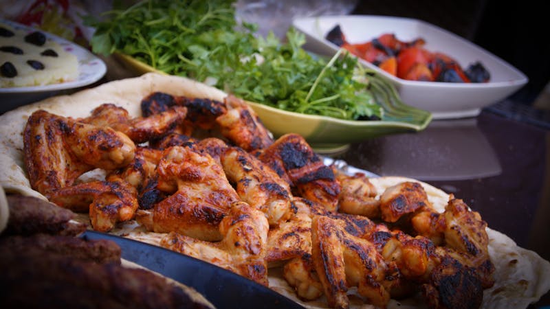 Wings over team preparing fresh wings over the grill